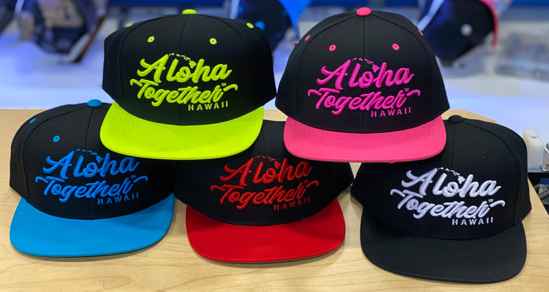 Colorful hat stack. Neon Yellow, Neon Pink, Neon Blue, Neon Red, and Black Hats.